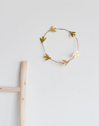 Notre couronne murale avec ses oiseaux en cuir et laiton accrochée au mur près d'une échelle en bois