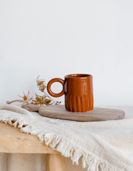 Notre tasse creusée terracotta posée sur une planche en noyer