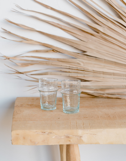 Notre duo de verre à thé marocain posés sur une table en bois près d'une feuille de palmier