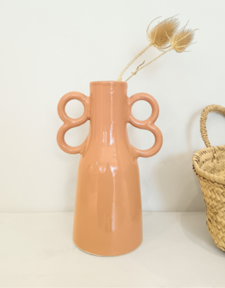 Notre vase corail avec ces jolies anses avec une fleur séchée et près d'un panier